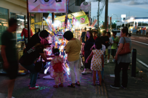 花火大会にて夜店を巡り歩く人々